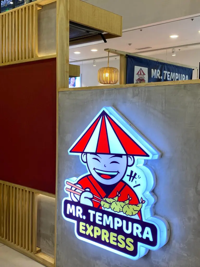 Interior shot of Mr. Tempura Express restaurant at Centrio, featuring a brightly lit logo and modern design.