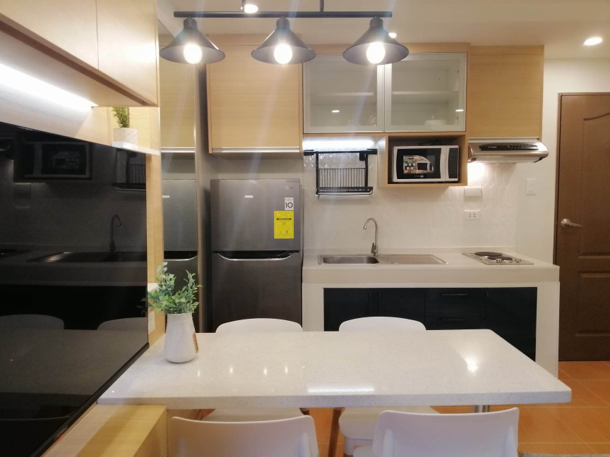 A modern and well-equipped kitchenette in a 2-bedroom unit, featuring sleek cabinetry, stainless steel appliances, and stylish lighting. The image highlights the unit's functional and aesthetically pleasing kitchen area.