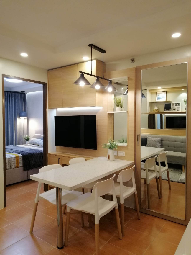 The dining area of a 2-bedroom unit, showcasing a modern dining table with chairs and a built-in entertainment center, highlighting the unit's efficient and aesthetically pleasing design.