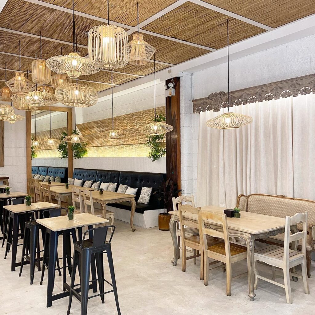 A restaurant interior featuring a warm and inviting atmosphere with natural lighting and unique woven pendant lights. The design is both stylish and comfortable.