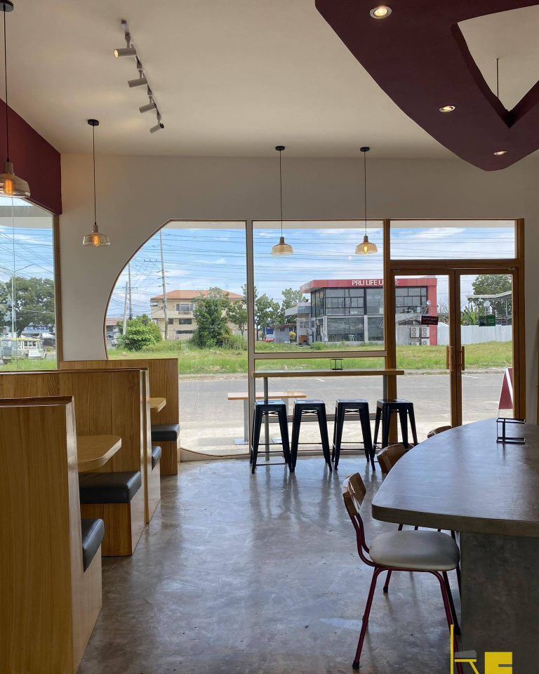 Demetrios Pizzeria features a bright and airy interior with ample natural light streaming through large windows.