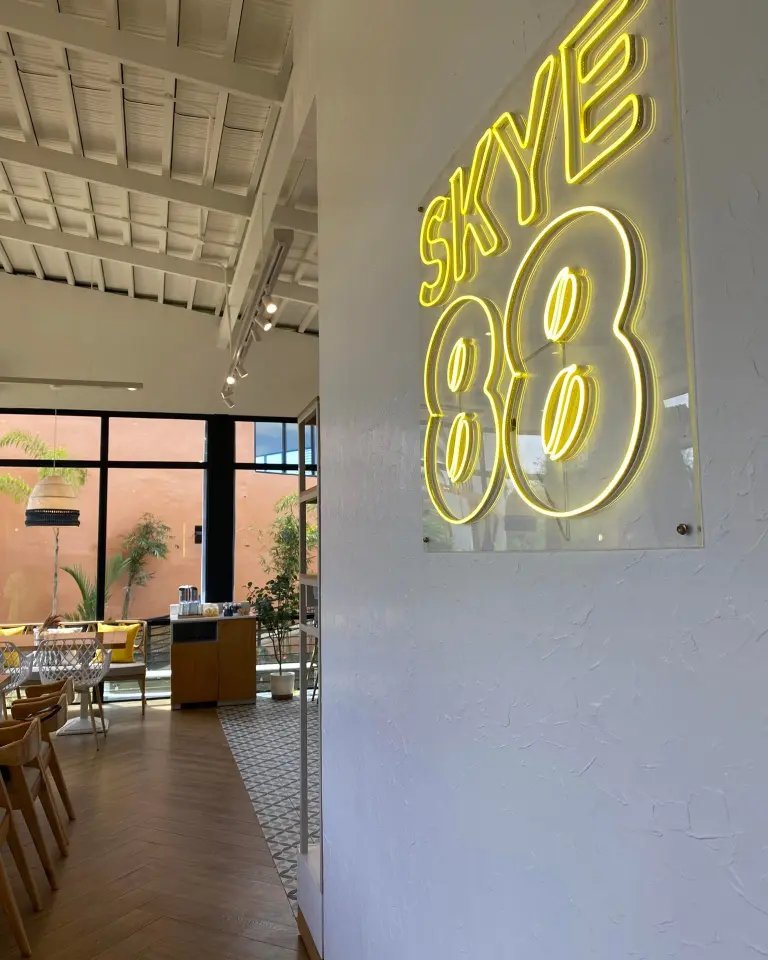 Neon sign for Skye 88, a restaurant or bar, mounted on a textured white wall.