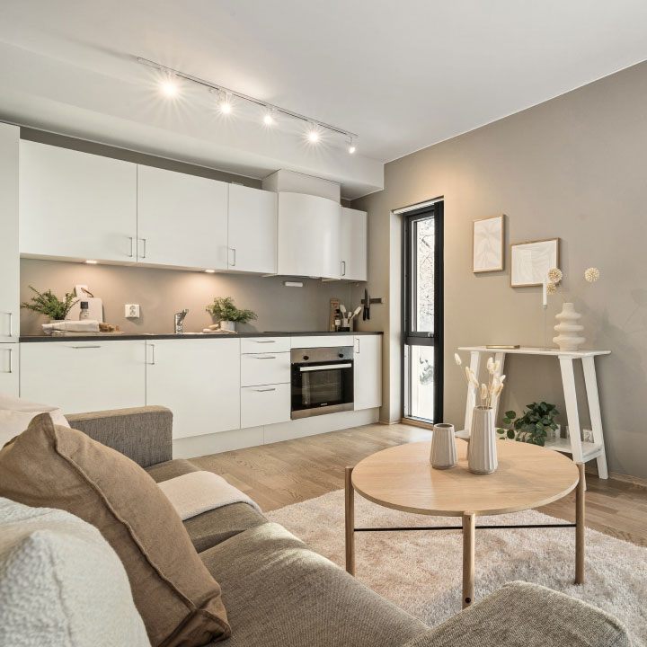 Modern open-concept kitchen and living room with neutral tones, Scandinavian-style furniture, and minimalist interior design.