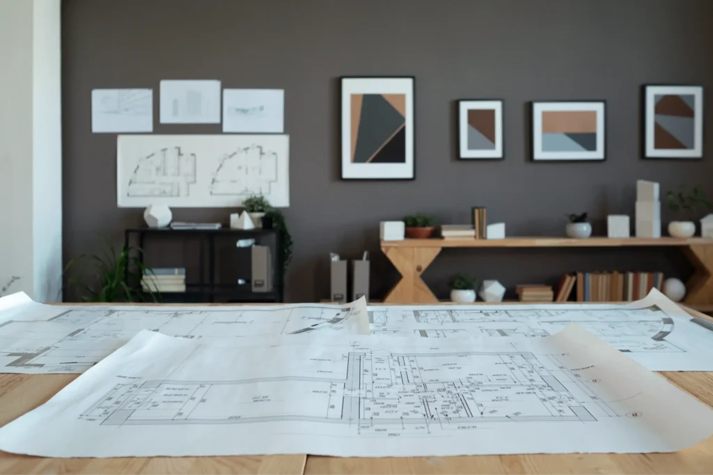 Modern office interior with blueprints, showcasing minimalist design and geometric artwork for space planning.