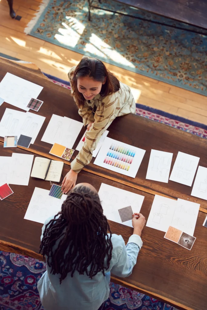 Two designers collaborate on a design project, reviewing and selecting material samples. The image emphasizes the importance of careful material and finish selection in achieving a successful design outcome.
